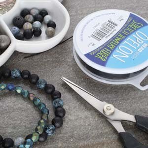 0.7 mm diameter Opelon black stretch bead and jewelry fiber, 5 meter spool. Make stretch bracelets & anklets. Medium weight, flat cord